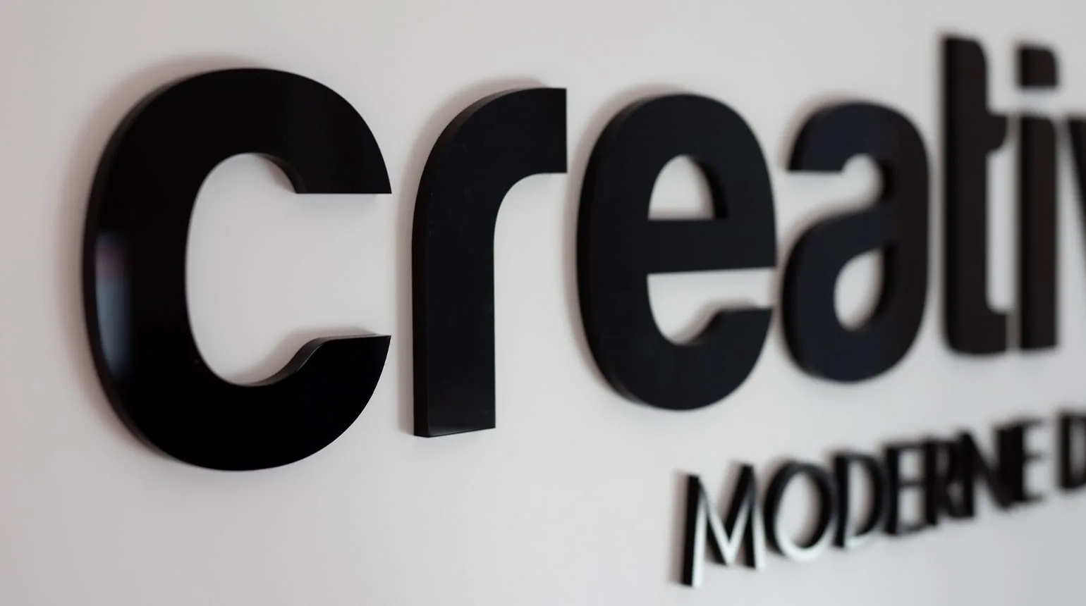 Schriftzug creativecouch als dreidimensionale Buchstaben an einer hellen Wand